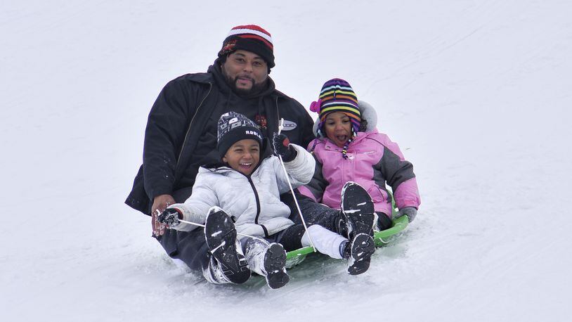 Anton Sheafe sleds down a hill with Alora Sheafe, 3, and Amir Sheafe, 4, at Voice of America MetroPark Thursday, February 18, 2021 in West Chester Twp. Many schools in the area were off for a snow day. NICK GRAHAM / STAFF