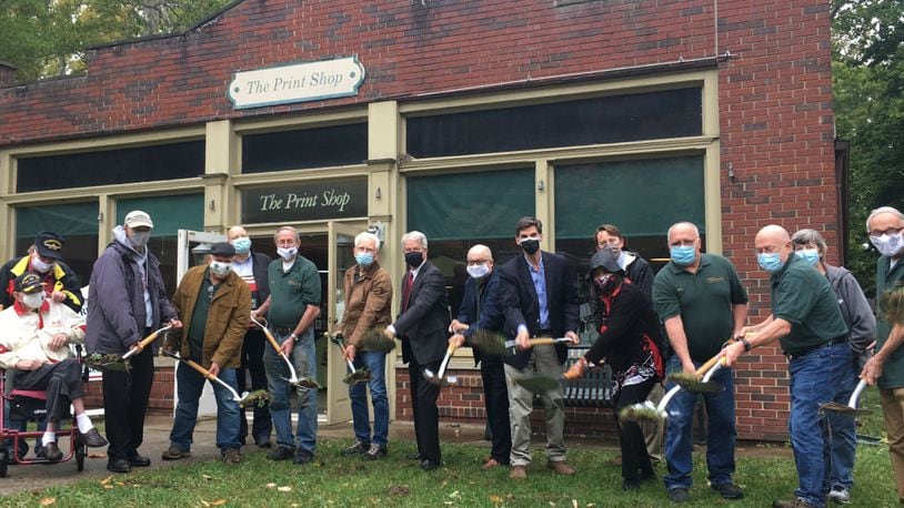 A group of Carillon Historical Park volunteers break ground on an expansion project of the park's Print Shop on Thursday.