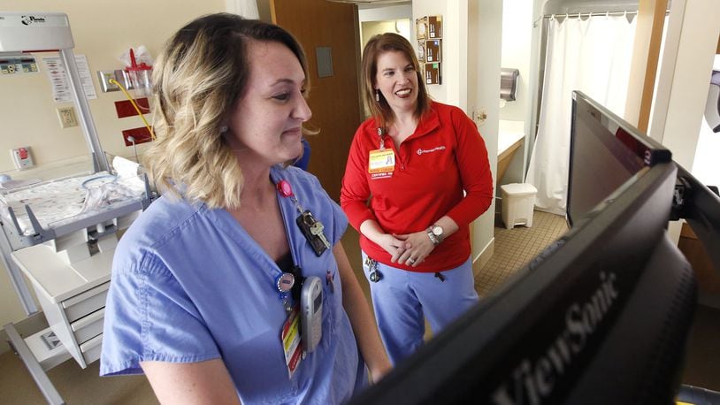 Emily Hayes, R.N., right, reviews patient records software with Adrienne Linville, R.N. at Miami Valley Hospital’s Berry Women’s Center. Demand for registered nurses is high and is reflected in the numbers of those leaving the profession. TY GREENLEES / STAFF