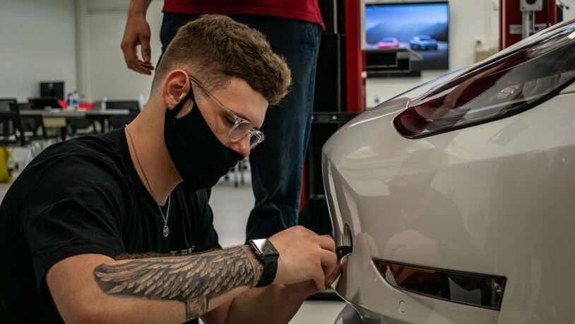 Sinclair College student Adam Shier works on a Tesla.