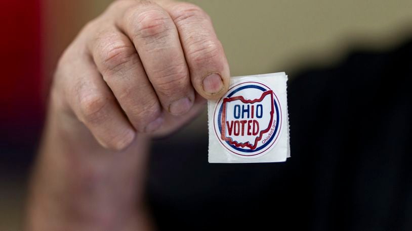 Voters grab "Ohio Voted" stickers after filling out ballots on Election Day at Chesapeake Elementary School on Tuesday, Nov. 7, 2023, in Chesapeake, Ohio. (Sholten Singer/The Herald-Dispatch via AP)
