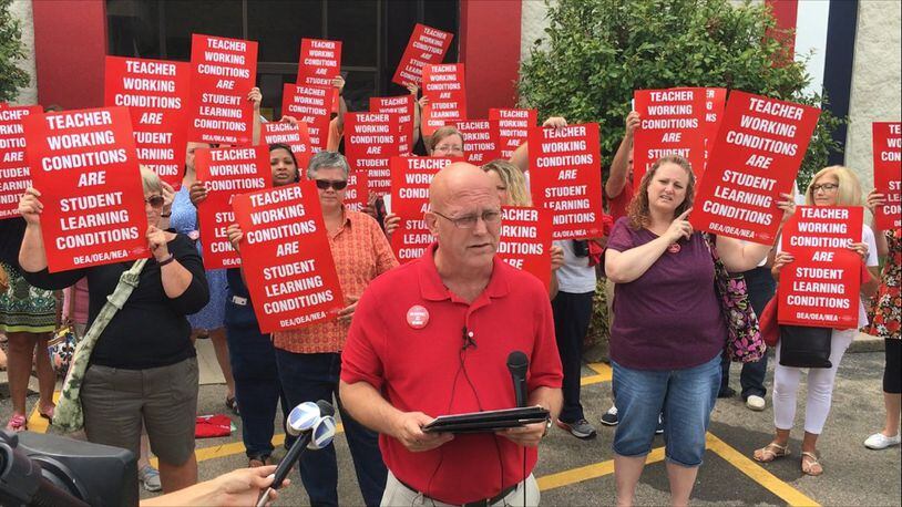 Dayton teachers union president David Romick explains the strike vote by his group Tuesday, Aug. 1, 2017, as other Dayton Education Association members stand in support. JEREMY P. KELLEY / STAFF