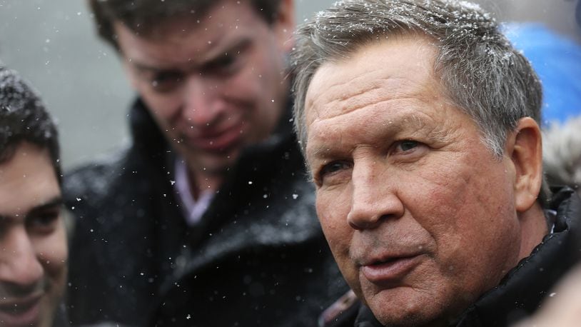 Snow begins to fall as Republican presidential candidate, Ohio Gov. John Kasich talks to reporters after a campaign stop at the public library before next Tuesday's first in the nation presidential primary, Monday, Feb. 8, 2016, in Plaistow, N.H. (AP Photo/Jim Cole)