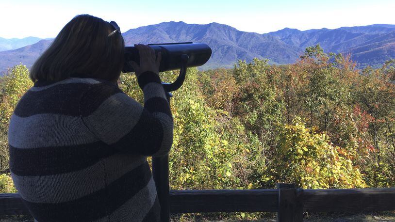 This Oct. 26, 2017 photo shows Amber McCarter, a 22-year-old from Tennessee who is colorblind, looks out from Mt. Harrison at the Ober Gatlinburg resort through a viewfinder designed to help see more colors. Tennessee tourism officials have installed the colorblind viewfinder there, in addition to viewfinders in two other scenic spots in the state. (AP Photo/Jonathan Matisse)