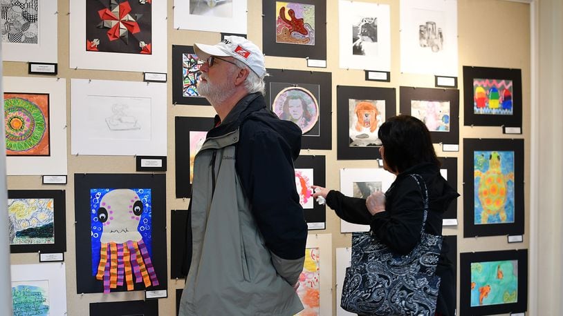 Visitors to the Troy-Hayner Cultural Center take in the annual Young Masters art exhibit, featuring works of students in the Troy-area schools. Contributed photos