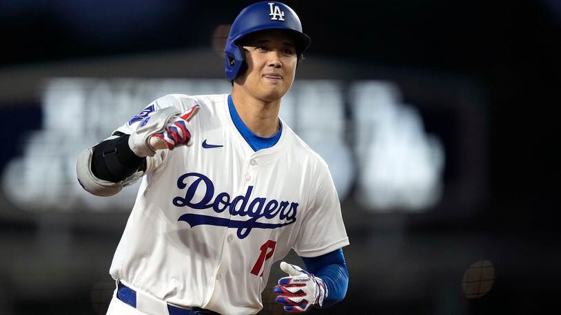 Los Angeles Dodgers' Shohei Ohtani gestures as he round third after hitting a solo home run during the first inning of a baseball game against the San Diego Padres Friday, April 12, 2024, in Los Angeles. (AP Photo/Mark J. Terrill)