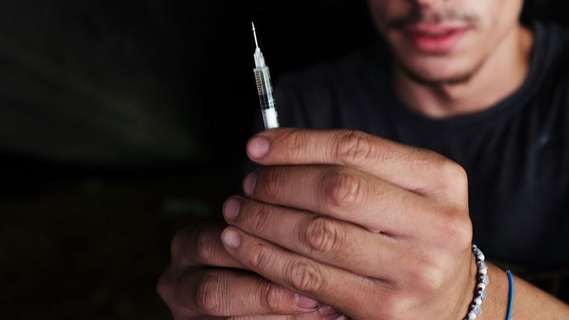A heroin addict pauses to shoot-up. New findings from the CDC says opioids, like heroin, kill more Americans than guns or breast cancer.
