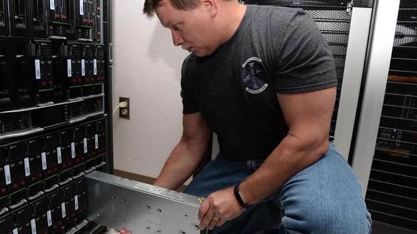Rich Figliola, 88th Medical Support Squadron system administrator, removes a Hewlett Packard Generation eight blade from a C7000 blade chassis for 88th MDSS at Wright-Patterson Air Force Base Medical Center, July 14. Figliola maintains the 88th MDSS servers for both physical and virtual network systems. (U.S. Air Force photos/Michelle Gigante)