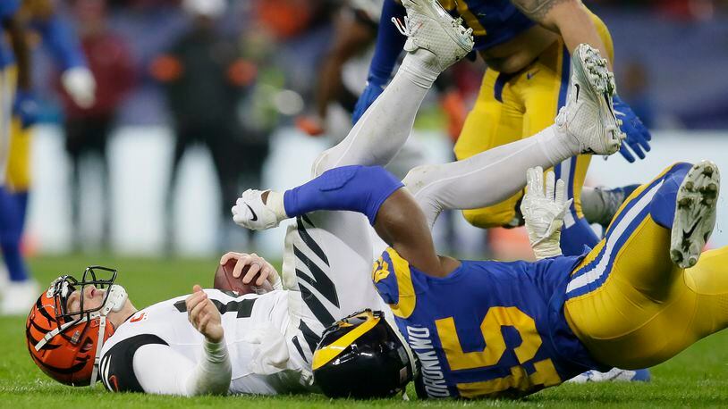 Cincinnati Bengals quarterback Andy Dalton, left, is sacked by Los Angeles Rams linebacker Obo Okoronkwo during the second half of an NFL football game, Sunday, Oct. 27, 2019, at Wembley Stadium in London. (AP Photo/Tim Ireland)