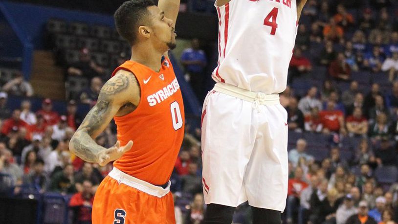 Dayton’s Charles Cooke shoots a 3-pointer against Syracuse’s Michael Gbinije in the first round of the NCAA tournament on Friday, March 18, 2016, at the Scottrade Center in St. Louis. David Jablonski/Staff