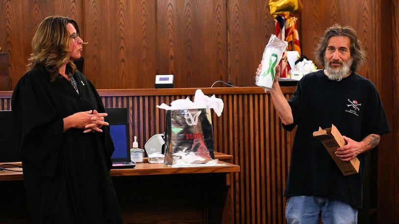 Miami County Judge Stacy Wall presents a gift from the county Mental Health Court program to its first graduate, Scott, a resident of Piqua. Wall presides over the now two-year-old court. CONTRIBUTED PHOTO