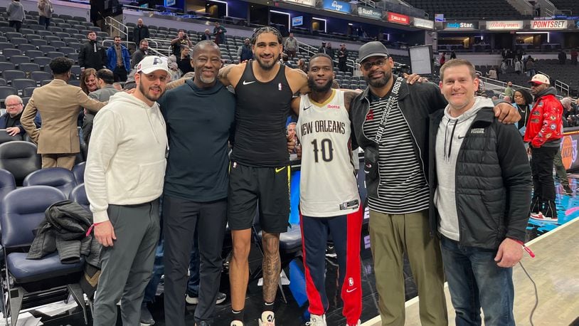 Dayton coaches pose with Obi Toppin and Jalen Crutcher after a game between the Pacers and Pelicans in Indianapolis on Wednesday, Feb. 28, 2024. From left to right are: James Kane, Anthony Grant, Obi Toppin, Jalen Crutcher, Ricardo Greer and Darren Hertz. Dayton Athletics photo