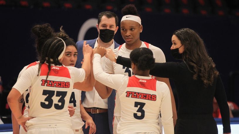 Dayton players huddle with coach Shauna Green during a game against Duquesne on Sunday, Jan. 3, 2020, at UD Arena. David Jablonski/Staff