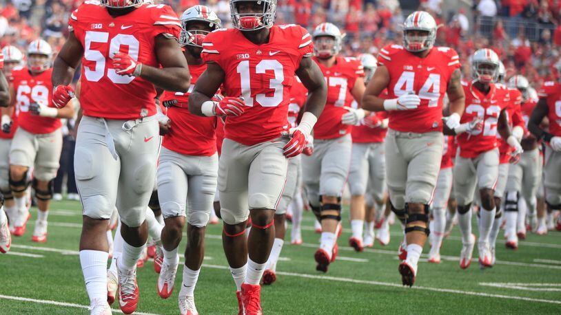 Ohio State players, including Tyquan Lewis (59) and Jalyn Holmes (13), take the field before a game against Northwestern on Saturday, Oct. 29, 2016, at Ohio Stadium in Columbus. David Jablonski/Staff