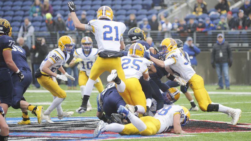 Marion Local’s Dylan Heitkamp (21), Brandon Fleck (25), Tanner Ungruhn (38) and Matt Everman (bottom) get defensive. Kirtland defeated Marion Local 16-7 in the D-VI high school football state championship at Canton’s Tom Benson Hall of Fame Stadium on Friday, Nov. 30, 2018. MARC PENDLETON / STAFF