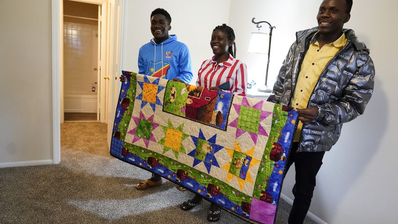 Refugees from Congo Sadock Ekyochi, from left, his wife Riziki Kashindi and her brother Kaaskile Kashindi pose for a photo inside their new apartment, Thursday, April 11, 2024, in Columbia, S.C. The American refugee program, which long served as a haven for people fleeing violence around the world, is rebounding from years of dwindling arrivals under former President Donald Trump. The Biden administration has worked to restaff refugee resettlement agencies and streamline the process of vetting and placing people in America. (AP Photo/Erik Verduzco)
