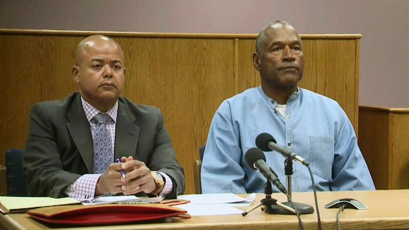 Former NFL football star O.J. Simpson appears with his attorney, Malcolm LaVergne, left, via video for his parole hearing at the Lovelock Correctional Center in Lovelock, Nev., on Thursday, July 20, 2017.  Simpson was convicted in 2008 of enlisting some men he barely knew, including two who had guns, to retrieve from two sports collectibles sellers some items that Simpson said were stolen from him a decade earlier. (Lovelock Correctional Center via AP)