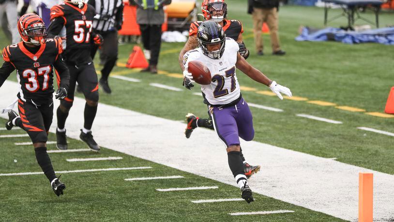 Baltimore Ravens running back J.K. Dobbins (27) dashes past Cincinnati Bengals cornerback Jalen Davis (37) and the rest of the defense for a touchdown during the second half of an NFL football game, Sunday, Jan. 3, 2021, in Cincinnati. (AP Photo/Aaron Doster)