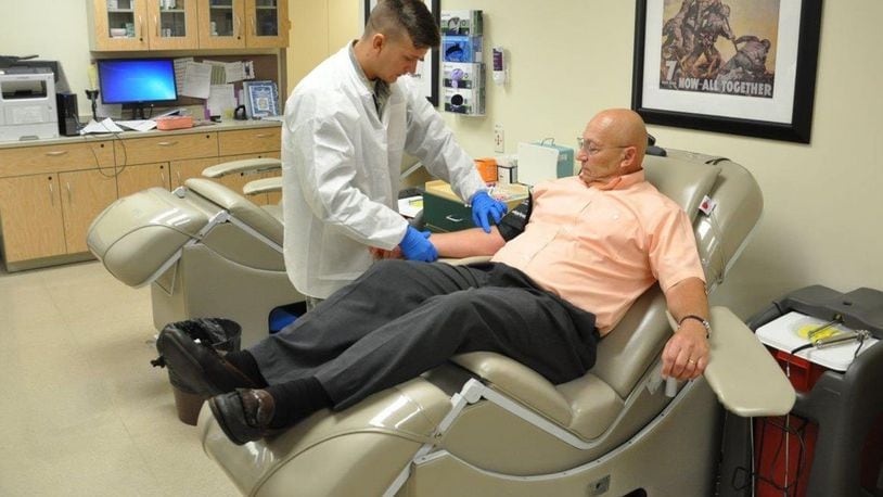 Senior Airman Tyler Bennett, medical laboratory technologist, prepares Dennis Lange, blood donor for a blood donation on Aug. 10 in Area A, Bldg. 830, Wright-Patterson Medical Center. (U.S. Air Force photo/W. Eugene Barnett Jr.)