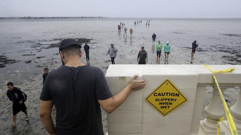 People venture into Tampa Bay after water recedes during Hurricane Irma.