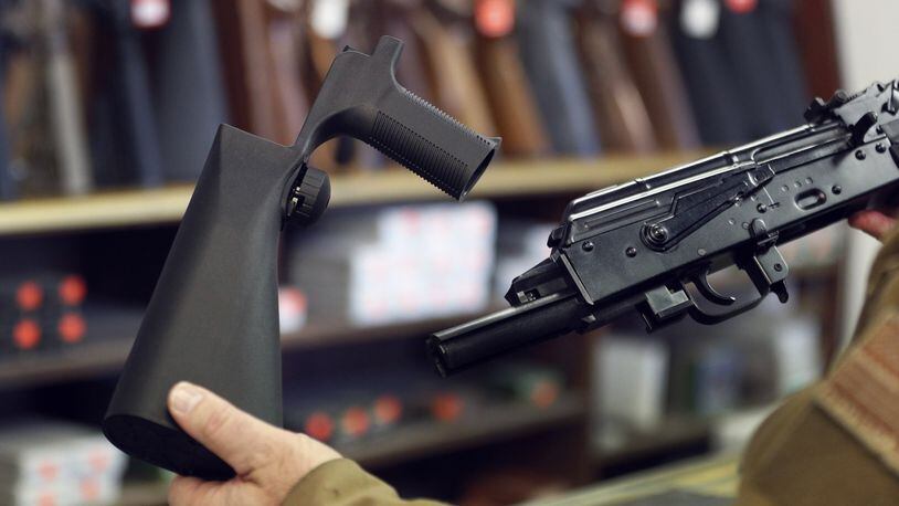 A bump stock device (left), that fits on a semi-automatic rifle to increase the firing speed, making it similar to a fully automatic rifle, is shown next to a AK-47 semi-automatic rifle (right), at a gun store on Thursday in Salt Lake City, Utah. Congress is talking about banning this device after it was reported to of been used in the Las Vegas shootings on Sunday.