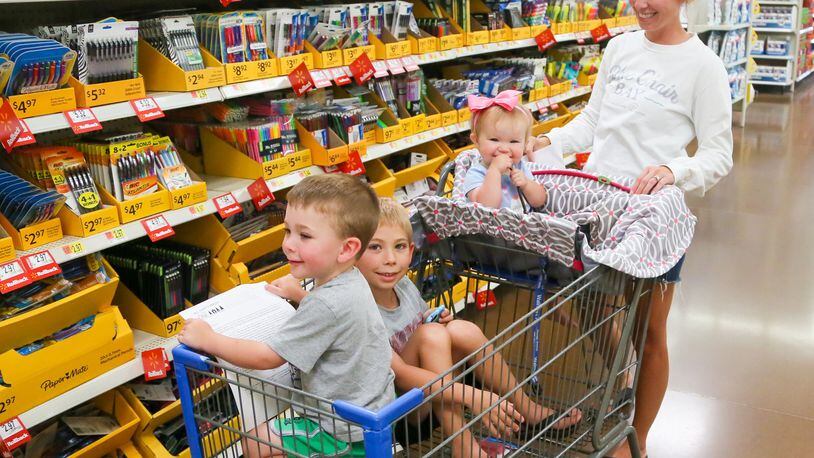 Brittany Rademacher, along with her kids, Ali, Mason and Camden, shop for back to school supplies at the Walmart in West Chester, Wednesday, July 26, 2017. GREG LYNCH / STAFF