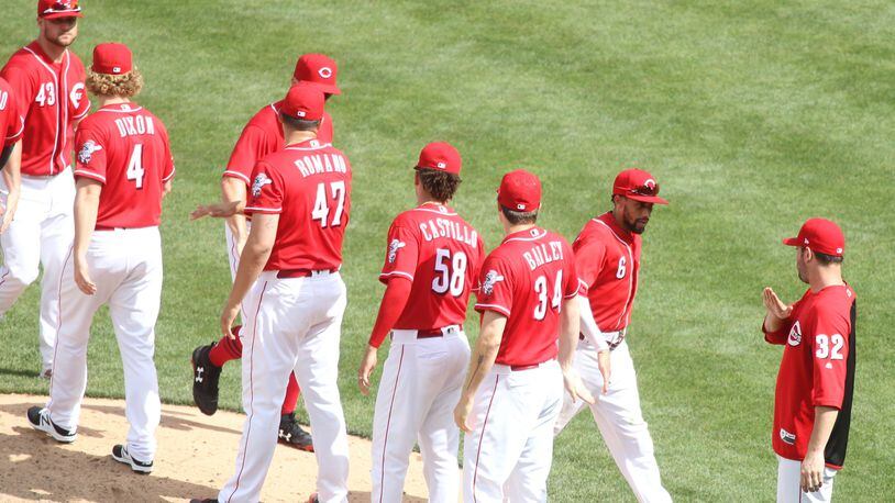 The Reds celebrate a victory over the Cardinals on Sunday, June 10, 2018, at Great American Ball Park in Cincinnati.