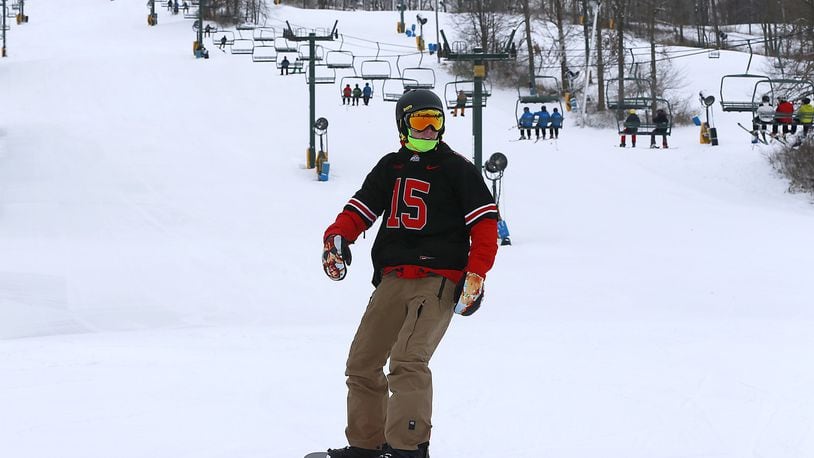 A snowboarder swishes down the slopes at Mad River Mountain earlier this month after it opened for season. The 14th annual Louie Vito Rail Jam for Charity will be held at Mad River on Saturday. Bill Lackey/Staff