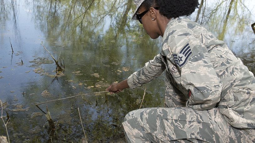 Staff Sgt. Brittany Wiggins, U.S. Air Force School of Aerospace Medicine public health instructor, skims the surface of Twin Lakes, Wright-Patterson Air Force Base, May 8 to look for mosquito larvae. When mosquito larvae is bothered or disturbed, the movement of larvae helps Wiggins capture the mosquito larvae for testing. (U.S. Air Force photo/Michelle Gigante)