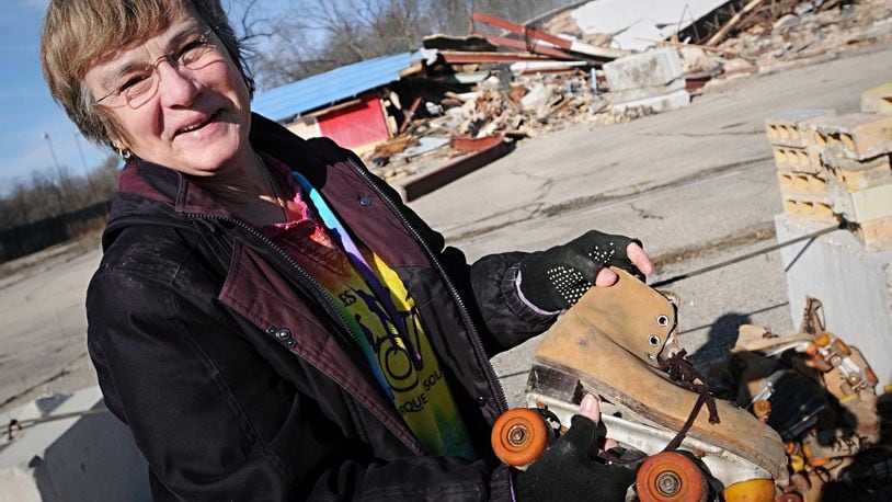 Betty Danks looks at one of the skates that the demolition crews set out by the edge of Haddix road for passerby’s that are looking for memorabilia from Skyborn Skateland Monday. STAFF/MARSHALL GORBY