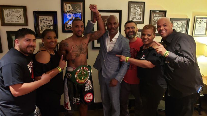 Trotwood native Chris Pearson has his arm raised by boxing great Bernard Hopkins after Pearson beat Yamaguchi Falcao for the WBO Latino Middleweight championship in Las Vegas. Pictured from left, co-trainer Edgar Jasso, Pearson s aunt Deborah Butler from Dayton, Chris Pearson, Bernard Hopkins, trainer Manny Robles, Chris’ aunt Alandis Powell from Dayton and Chris’ dad Milton Pearson. CONTRIBUTED
