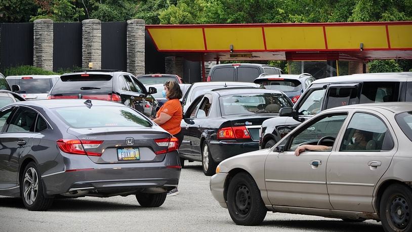 Vehicles line up to enter the Dixie drive-in for the Foodbank mass food distribution Aug. 16. Foodbanks are among those advocating for some of the remaining Ohio ARPA rescue funds.  MARSHALL GORBY\STAFF