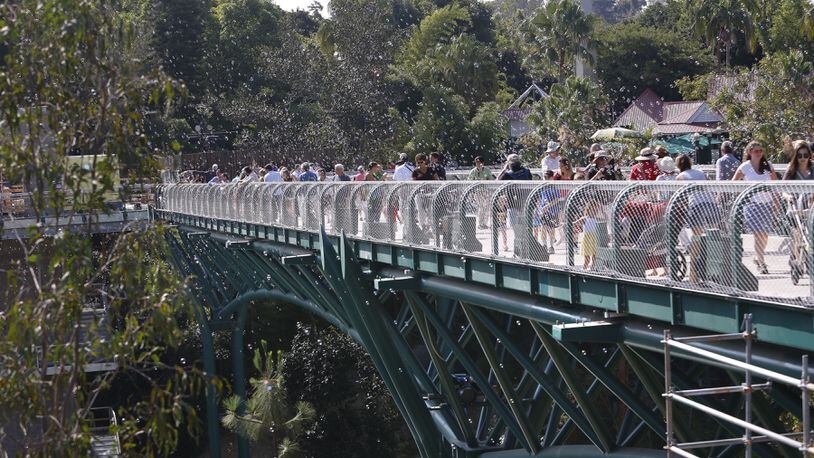 The first San Diego Zoo visitors to cross the new Canopy Bridge, a 450-foot long pedestrian bridge linking the front of the zoo to the back of the zoo, were treated to a parade, complete with mascots, puppeteers, bubbles and a brass band on July 28, 2017. (Howard Lipin/San Diego Union-Tribune/TNS)