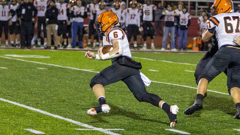 Versailles quarterback Carson Bey runs for a first down during the first half Saturday night against Preble Shawnee at Trotwood-Madison High School. Bey scored on the next play. jeff Gilbert/CONTRIBUTED