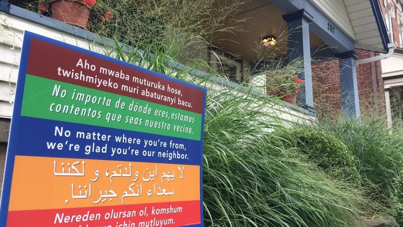 A sign outside a home in the South Park neighborhood sends a welcoming message to people who speak other languages. Dayton’s attitudes toward immigrants moving next door remain nearly unchanged from last year. CORNELIUS FROLIK / STAFF