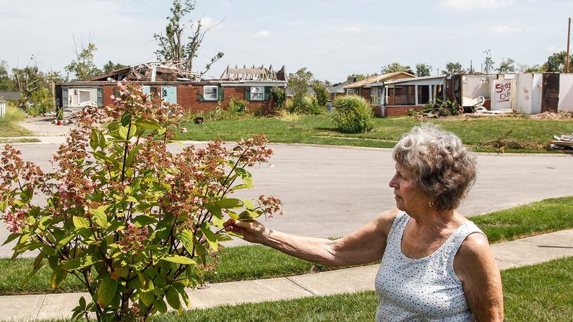 Lillian Martin of Brookville planted a new tree to replace one in her front yard destroyed on Deger Court along with several of her neighbors’ homes. CHRIS STEWART / STAFF