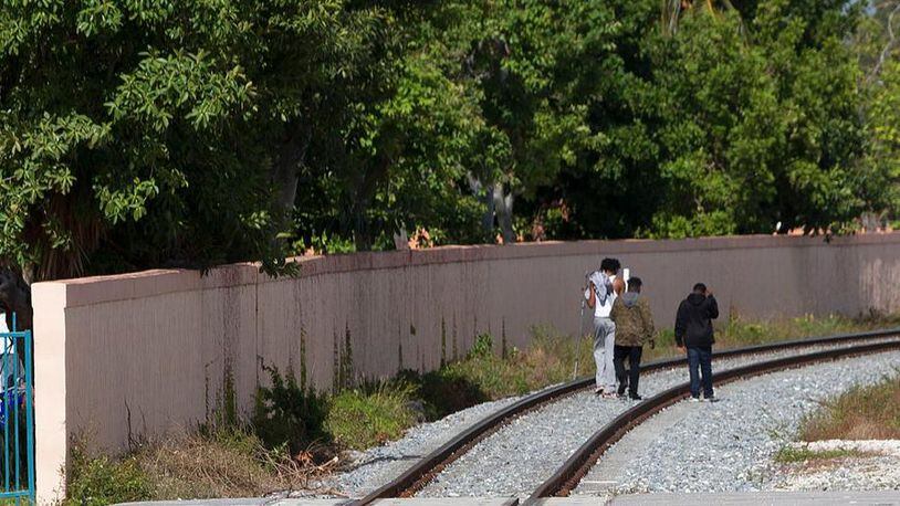 A group of boys trespass along railroad tracks next to a Brightline train station, Thursday, Jan. 11, 2018, in West Palm Beach, Fla. The Brightline train will begin introductory service on Saturday, with round-trip fares starting at $20 between its Fort Lauderdale and West Palm Beach stations. (AP Photo/Wilfredo Lee)