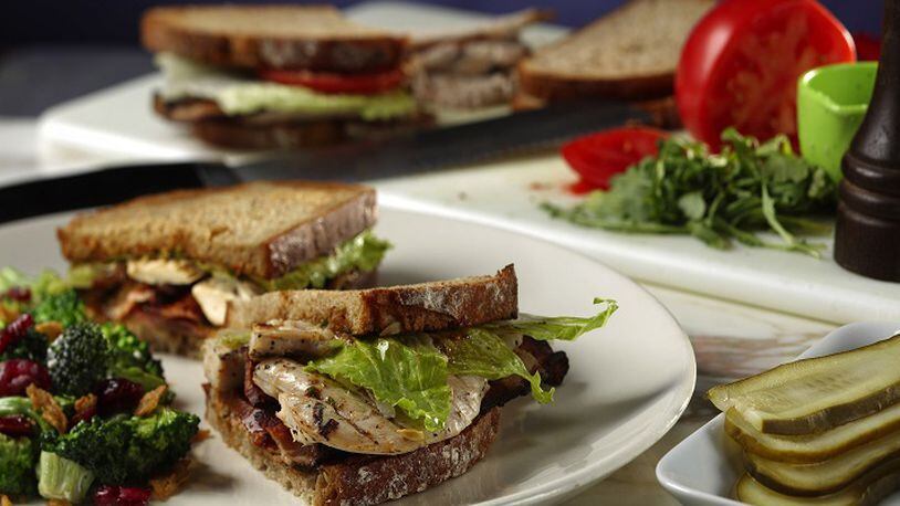 Roast chicken and crispy bacon are layered on thick multigrain bread slices slathered with a sun-dried tomato pesto and chopped arugula mayo and finshed with romaine. (Abel Uribe/Chicago Tribune/TNS)