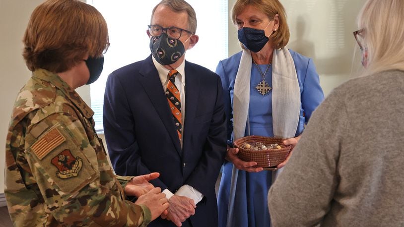 Governor Mike DeWine and his wife, Fran, visit with a woman who just got her COVID vaccinaton and a member of the National Guard assisting at the COVID vaccination clinic at New Carlisle Senior Living.  BILL LACKEY/STAFF