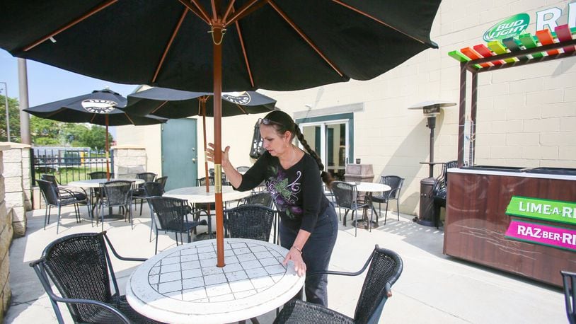 Owner Linda Moorman sets up one of the patio tables on Thursday at Murphy’s Landing in Middletown. A pair of state bills could allow owners of restaurants to permit people to bring their pets as they dine outdoors. GREG LYNCH/STAFF