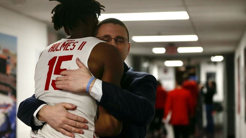 Dayton Athletic Director Neil Sullivan hugs DaRon Holmes II after a victory against Massachusetts on Friday, March 11, 2022, in the quarterfinals of the Atlantic 10 Conference tournament at Capital One Arena in Washington, D.C. David Jablonski/Staff