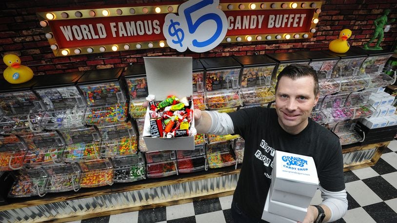 T.J. Parks, retail operations manager for Grandpa Joe's Candy Shop, stands by the newly renovated Miamisburg stores world famous $5 candy buffet. MARSHALL GORBY/STAFF