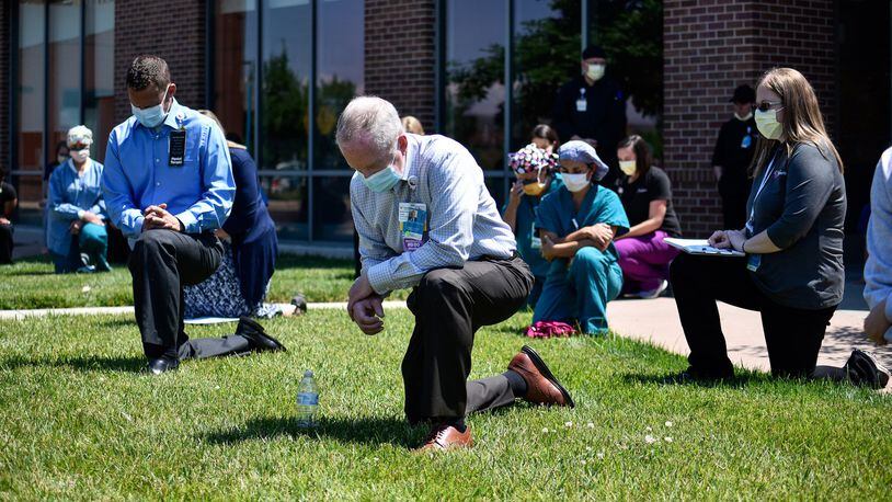 Nearly fifty employees kneeled for eight minutes and 46 seconds for a period of silence to reflect on racial injustice during a Juneteenth event outside of Cincinnati Children’s Liberty Campus Friday, June 19, 2020 in Liberty Township. Cincinnati Childrenâ€™s employees take a knee in recognition that black lives matter, and in support of their employees, patients, families and communities. NICK GRAHAM / STAFF