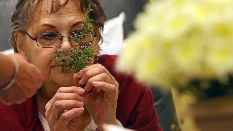 Fran Niemeyer-Murphy, of Fenton, smells an aromatic clipping to build a therapeutic bouquet as she gets treatment on Thursday, Nov. 30, 2017, at Siteman Cancer Center. Jeanne Carbone, a therapeutic horticulture instructor, offers therapeutic horticulture outreach at local medical and trauma centers through a program at the Missouri Botanical Garden. (Christian Gooden/St. Louis Post-Dispatch/TNS)