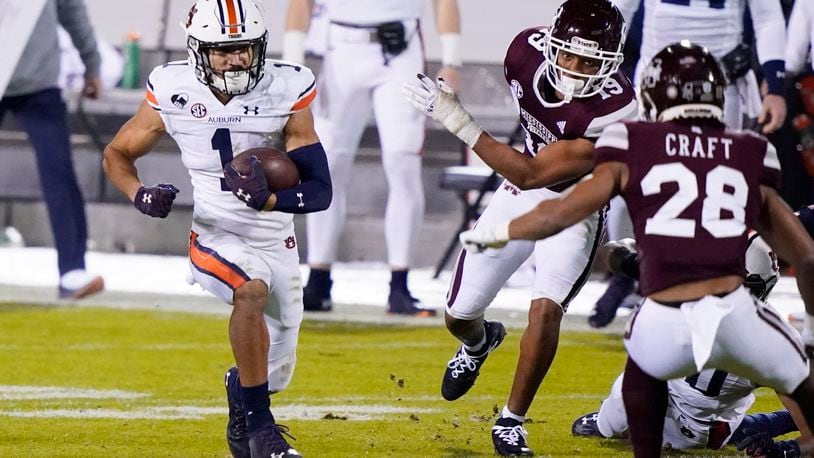 Auburn wide receiver Anthony Schwartz (1) runs with a reception past Mississippi State defenders for a first down during the first half of an NCAA college football game Saturday, Dec. 12, 2020, in Starkville, Miss. (AP Photo/Rogelio V. Solis)