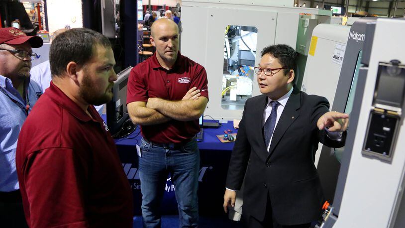 Finding the right workers and controlling costs are among the top worries that Dayton Region Manufacturers Association members have, according to a just-released survey from DRMA. In this 2015 photo, a production manager demonstrates a CNC multi-axis mill turn machine at DRMA’s annual trade show. JIM WITMER/STAFF
