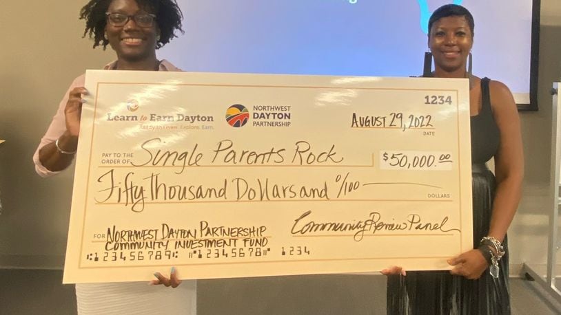 Learn to Earn Dayton's Nina Carter (left) presents a $50,000 grant to Denise Henton for the group Single Parents Rock. Learn to Earn's Northwest Dayton Partnership issued $1.45 million in grants to 28 groups that applied. CONTRIBUTED PHOTO