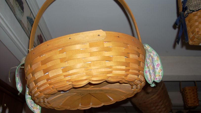 A Longaberger basket tagged for sale at a recent Kettering estate sale hung from the ceiling with a group of other baskets in the owner’s collection.