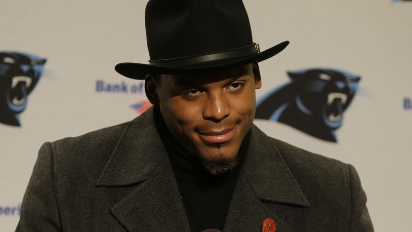 Carolina Panthers quarterback Cam Newton wears a black coat and hat as he talks with reporters during a post-game news conference after an NFL football game, Sunday, Dec. 4, 2016, in Seattle. The Seahawks won 40-7. (AP Photo/Stephen Brashear)