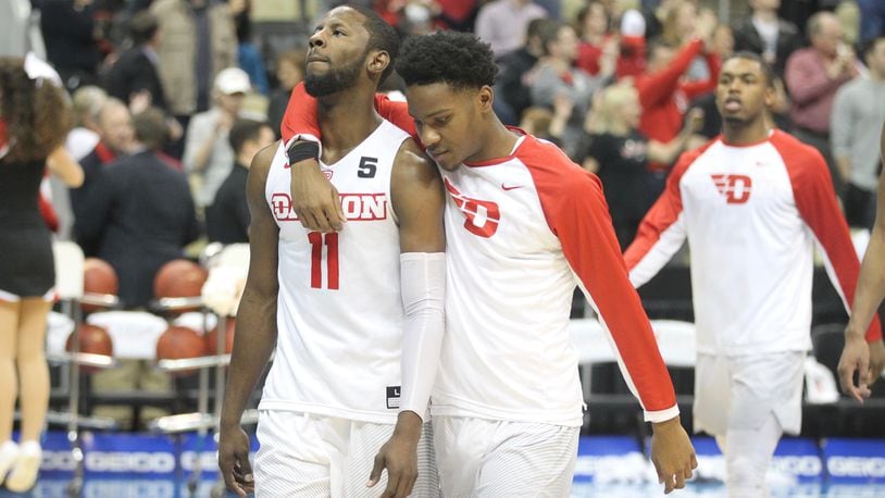 Dayton’s Scoochie Smith and John Crosby leave the court after a loss to Davidson on March 10, 2017, at PPG Paints Arena in Pittsburgh. David Jablonski/Staff